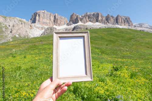 Empty wooden picture frame mockup in sunlight with mountains in the background. Summer vacation in the mountains. Template for articles and equipment for the mountain. Advertising for natural products