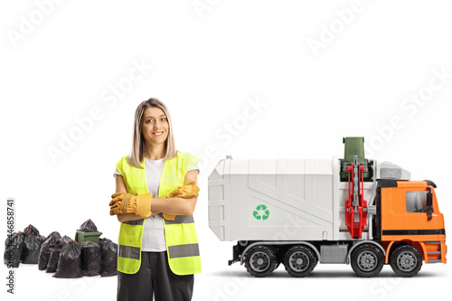 Female waste collector in a uniform with a garbage truck photo