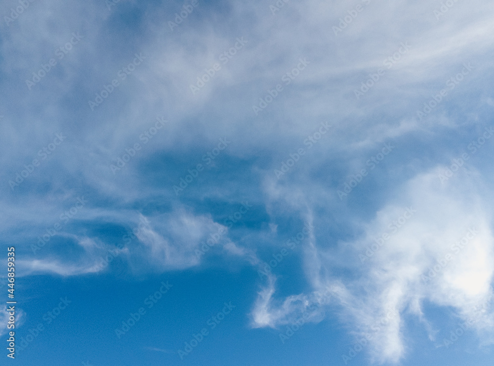 summer blue sky illuminated by the sun and illuminated by white fluffy clouds. Natural background for design, copy space. summer blue sky illuminated by the sun and illuminated by white fluffy clouds. Natural background for design, copy space.