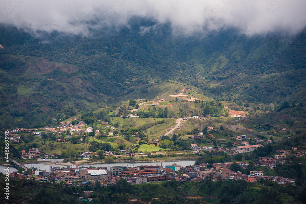 Medellin Colombia landscape with clouds on top of hillside of homes.