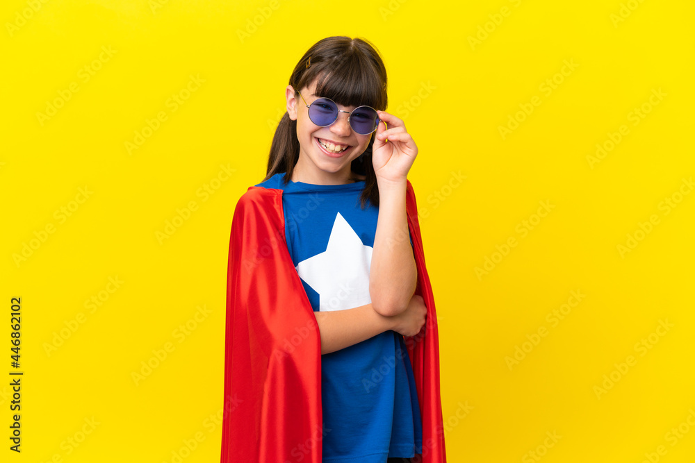 Little super hero kid isolated on purple background with glasses and happy