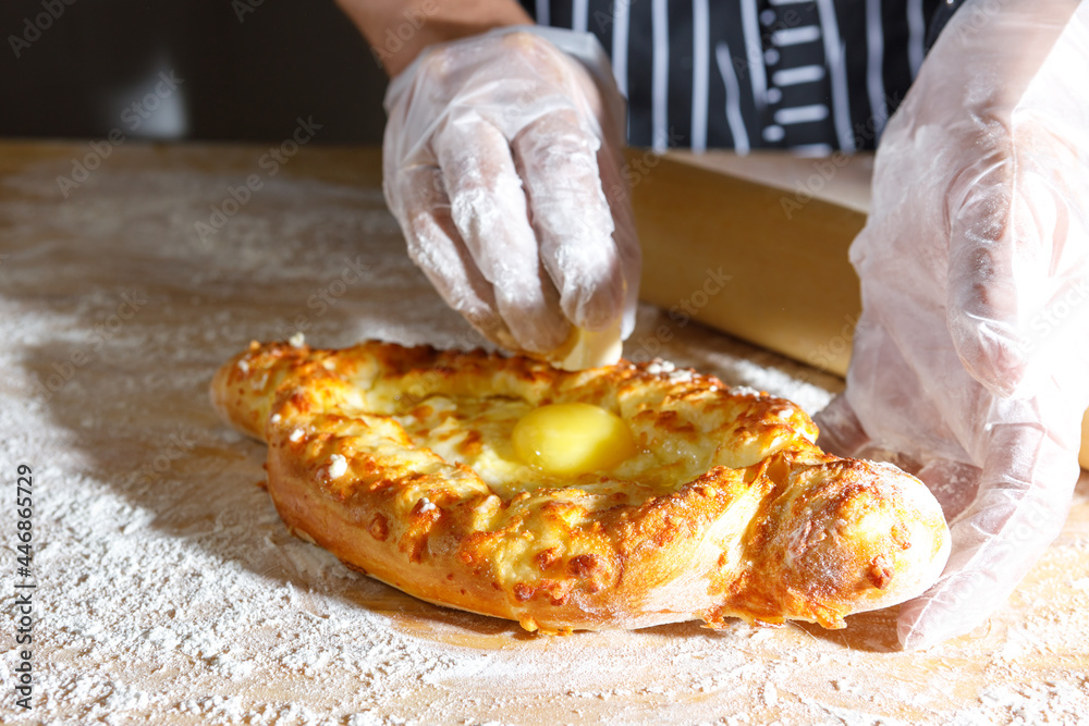 The chef's hands lubricate fresh pastries with butter.