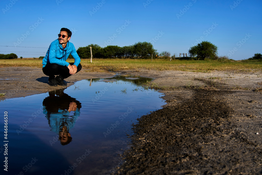Obraz premium Young man smiling reflected in water