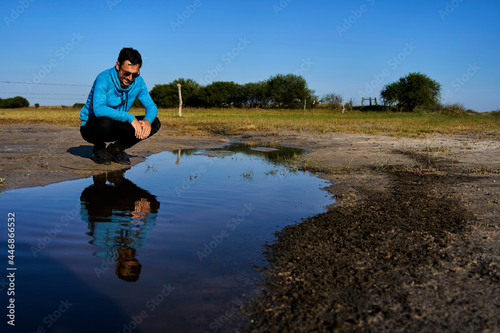 Fototapeta premium Young man smiling reflected in water