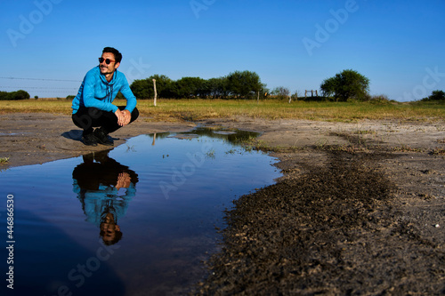 Young man smiling reflected in water photo