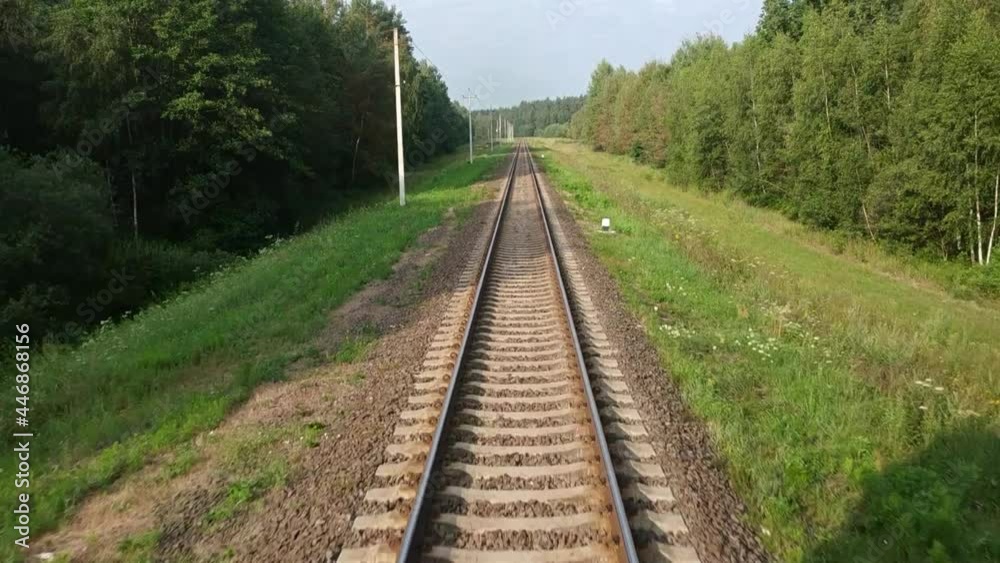 view from the window of the last carriage of a moving train on a sunny summer day. 