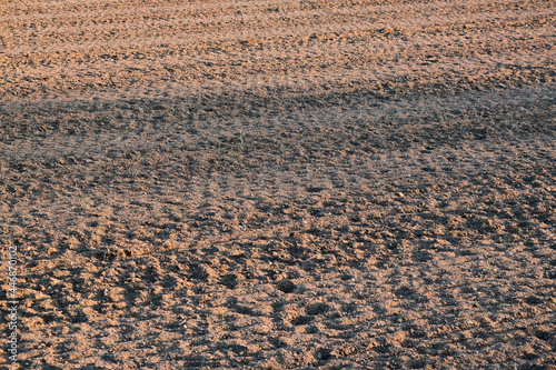 Furrows row pattern in a plowed field prepared for planting crops in spring. © Cavan