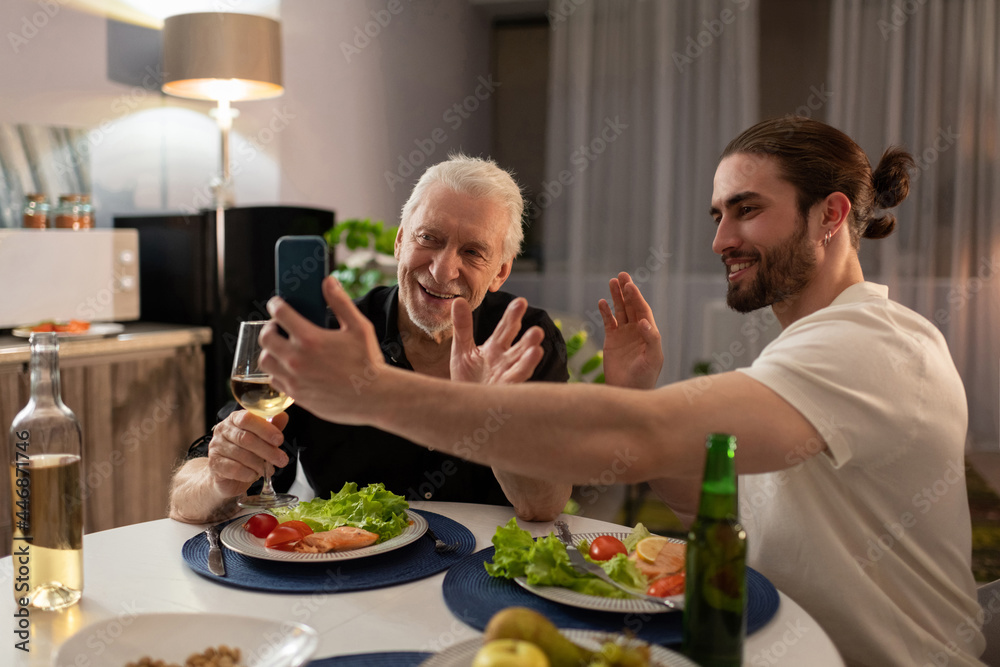 Grandfather and grandson making video call on cellphone Grandfather and grandson making video call on cellphone