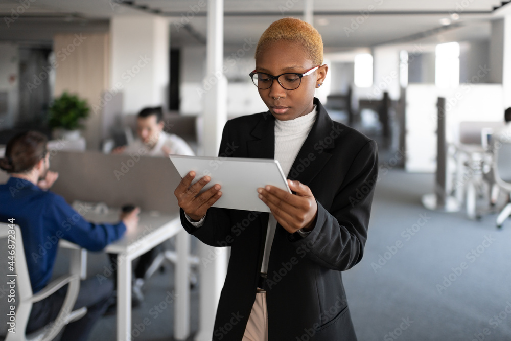 © Cavan Images - Black female manager browsing tablet