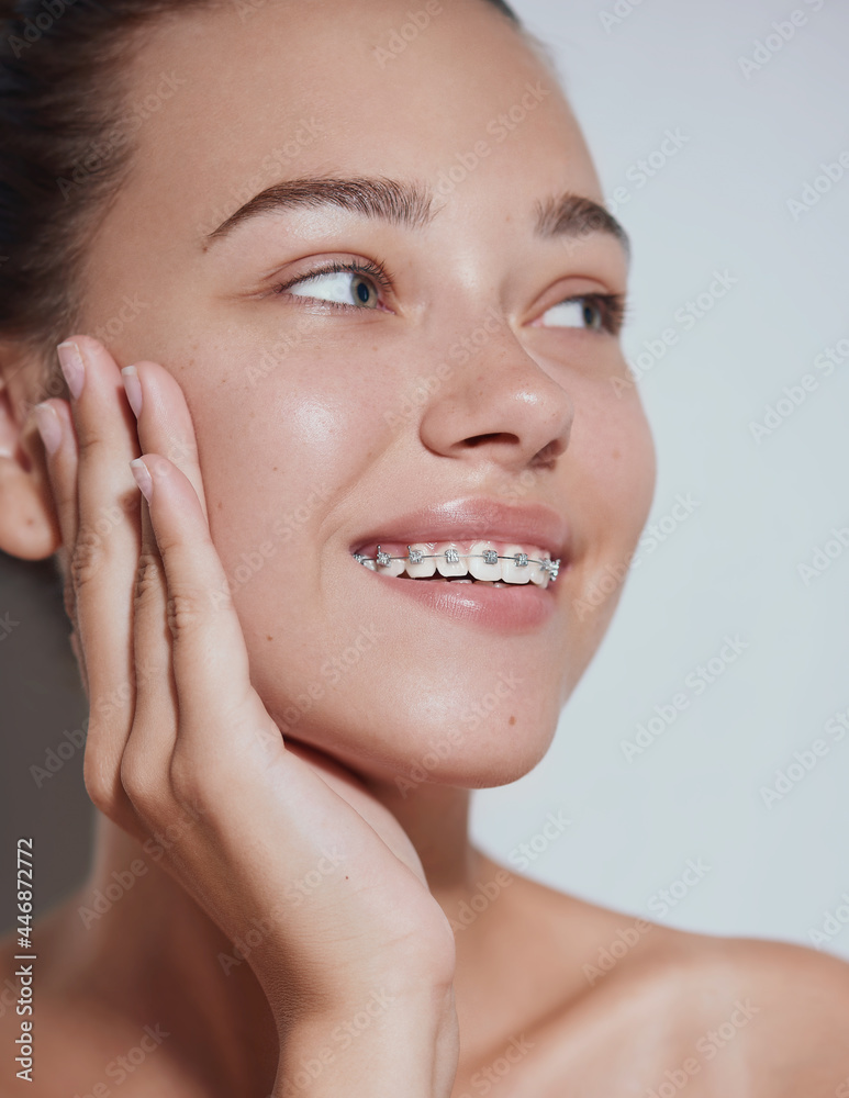 Young beautiful woman with clean fresh skin with braces smiling - white background Young beautiful woman with clean fresh skin with braces smiling - white background