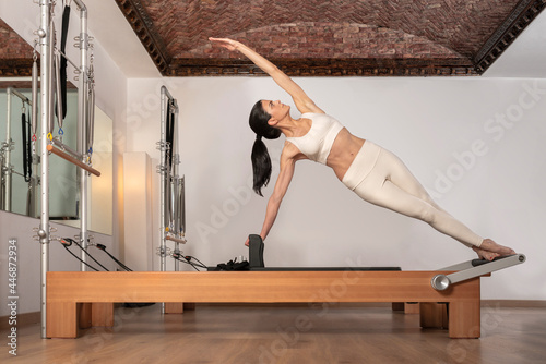 brunette girl doing pilates exercise for the oblique abdominals photo