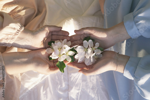 Close up of flowers in the hands of teenagers sitting on the bed