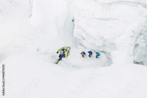 Climber on rappel while team navigates icefall photo