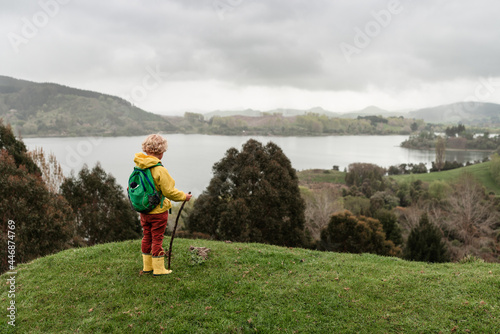 Child with backpack overlooking lake in New Zealand photo