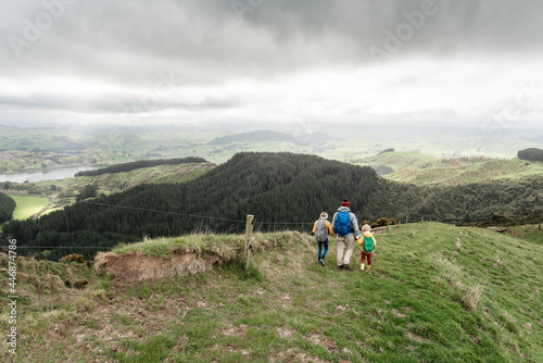 Father and children holding hands on hike in New Zealand mountains photo