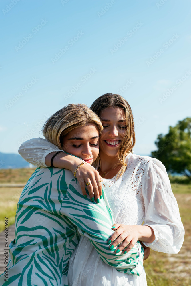Smiling female best friends hugging each other Smiling female best friends hugging each other