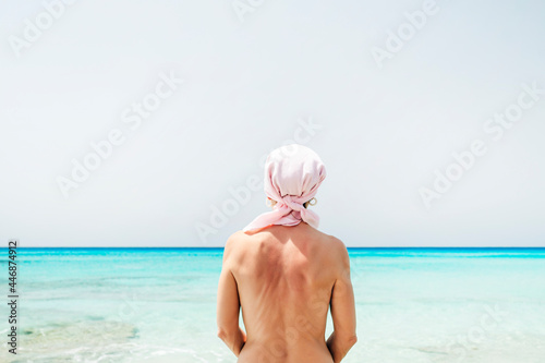 Naked woman with pink scarf on the beach, has cancer photo