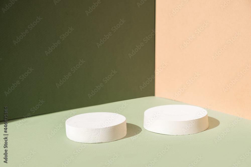 Abstract minimal scene with geometrical forms. Cylinder podiums on green and beige background. Abstract background. Scene to show cosmetic podructs. Showcase, display case. 3d render. Abstract minimal scene with geometrical forms. Cylinder podiums on green and beige background. Abstract background. Scene to show cosmetic podructs. Showcase, display case. 3d render.