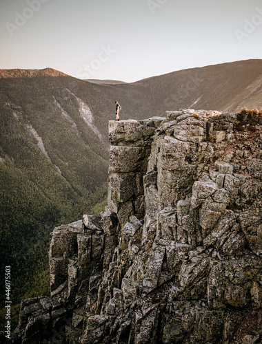 Male trail runner stands at edge of cliff on Bondcliff, New Hampshire photo