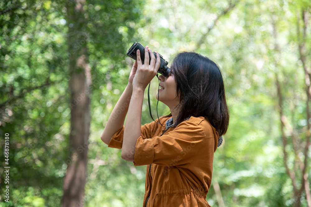 Asian woman use binoculars for a bird watching or a beautiful view Asian woman use binoculars for a bird watching or a beautiful view