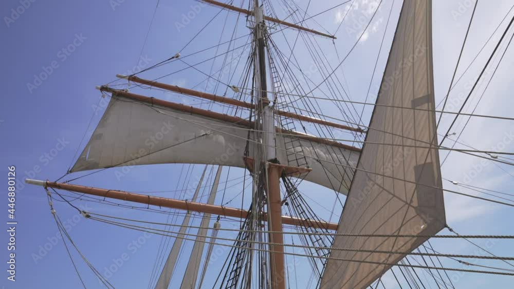 This video shows an old antique sailboat pirate ship with sails against a bright blue sky. This video shows an old antique sailboat pirate ship with sails against a bright blue sky.
