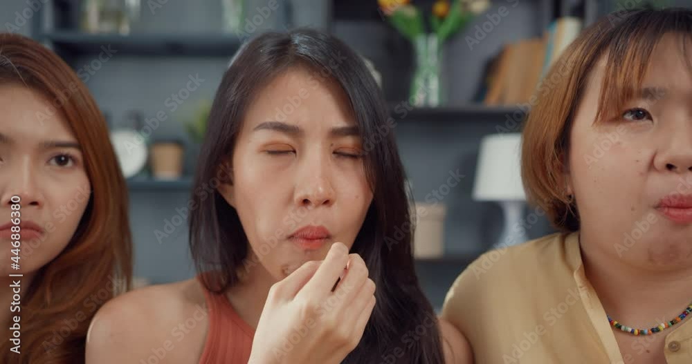 Attractive Asian lovely lady girl group positive glad cheerful with casual have fun and enjoy watch online movie entertainment on couch in living room at home. Lifestyle activity quarantine concept. Attractive Asian lovely lady girl group positive glad cheerful with casual have fun and enjoy watch online movie entertainment on couch in living room at home. Lifestyle activity quarantine concept.