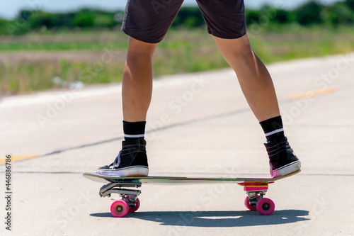 Close Up A young Asian man's legs are skateboarding on a country road on a sunny and clear day., Play surf skate.