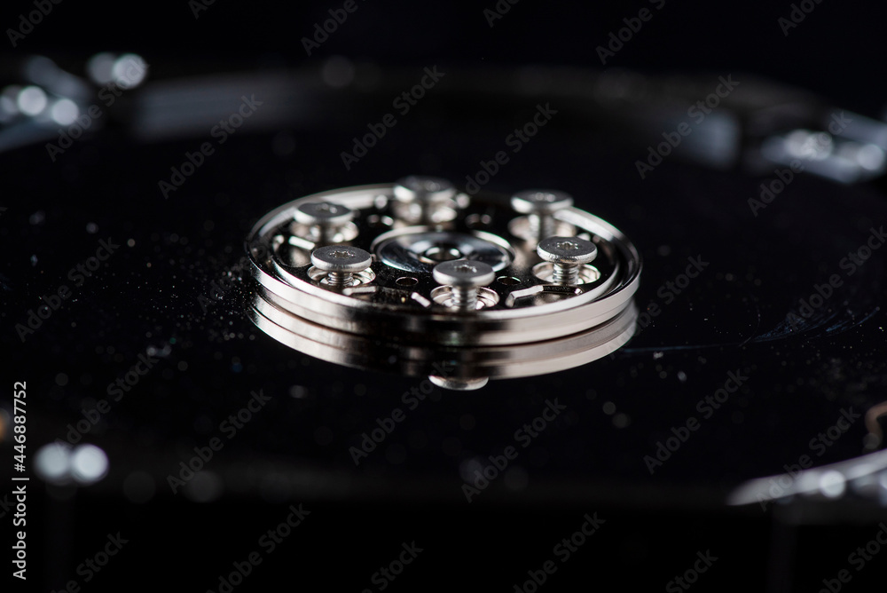 Fragment of a disassembled hard drive, against a dark background. Fragment of a disassembled hard drive, against a dark background.