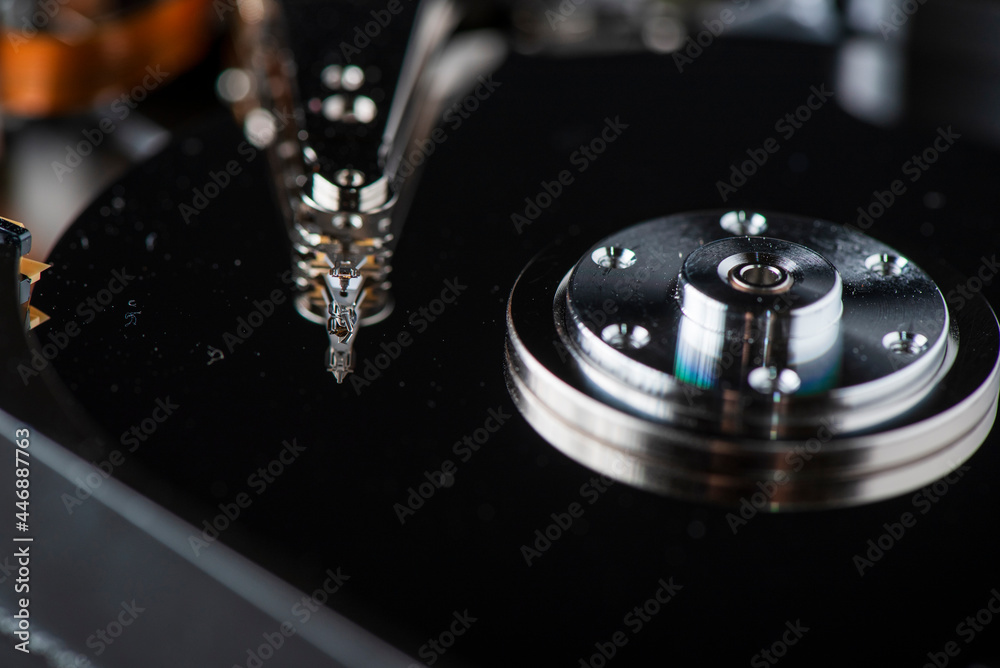 Fragment of a disassembled hard drive, against a dark background. Fragment of a disassembled hard drive, against a dark background.
