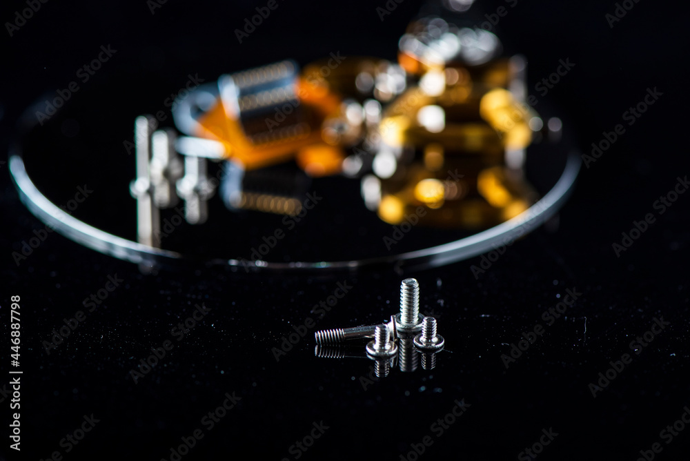 Fragment of a disassembled hard drive, against a dark background. Fragment of a disassembled hard drive, against a dark background.
