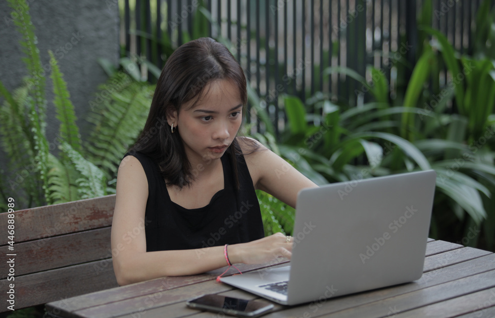 Portrait of a serious businesswoman using laptop in the home garden Portrait of a serious businesswoman using laptop in the home garden