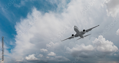 A white passenger plane flying over storm clouds