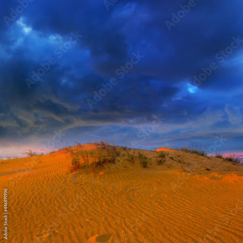 sandy desert dune under dense dramatic cloudy sky