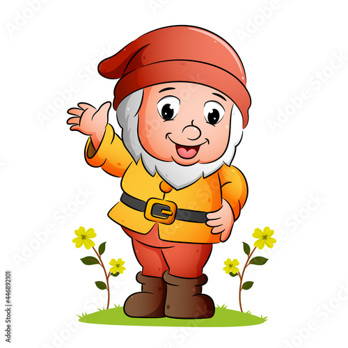 The happy dwarf is waving and smiling in the garden