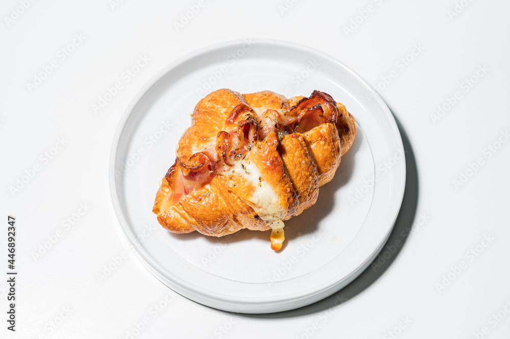 Croissants in a bakery shop. freshly baked croissants with bacon on white plate.