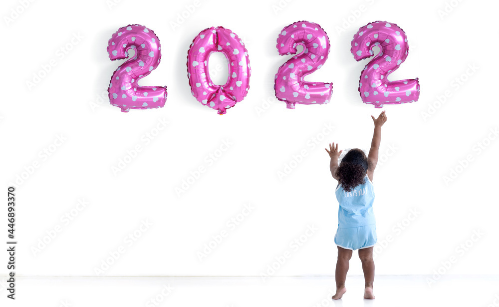 Dark skinned little girl with afro hair is arranging balloons for new year 2022, Pink party balloons 2022 numbers shape, white background Dark skinned little girl with afro hair is arranging balloons for new year 2022, Pink party balloons 2022 numbers shape, white background