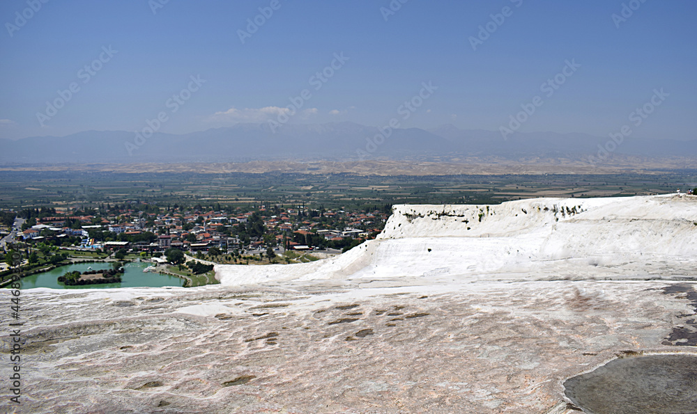 A landscape with a travertine-covered mountainside in the foreground.