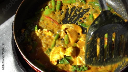 Chef cooking spicy Thai style food, pork with red curry