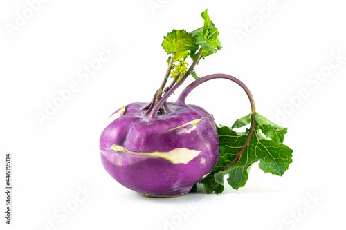Kohlrabi cabbage with purple skin and green leaves, isolated on a white background