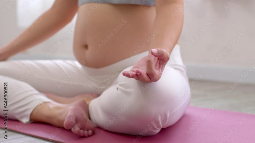 Close up Pregnant Woman sit on yoga mat and doung yoga lotus pose at cozy home,Pregnancy of young woman enjoy with yoga to breathing and meditation at home,Yoga Motherhood and Pregnant Concept Close up Pregnant Woman sit on yoga mat and doung yoga lotus pose at cozy home,Pregnancy of young woman enjoy with yoga to breathing and meditation at home,Yoga Motherhood and Pregnant Concept