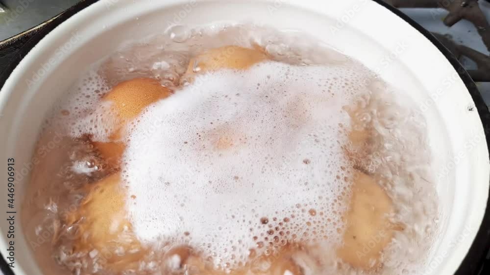 Brown chicken eggs during boiling in small saucepan Brown chicken eggs during boiling in small saucepan