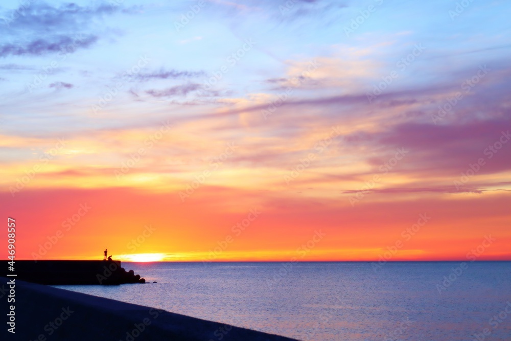 オレンジ色と水色の夕焼け空が美しい海と空の穏やかな風景