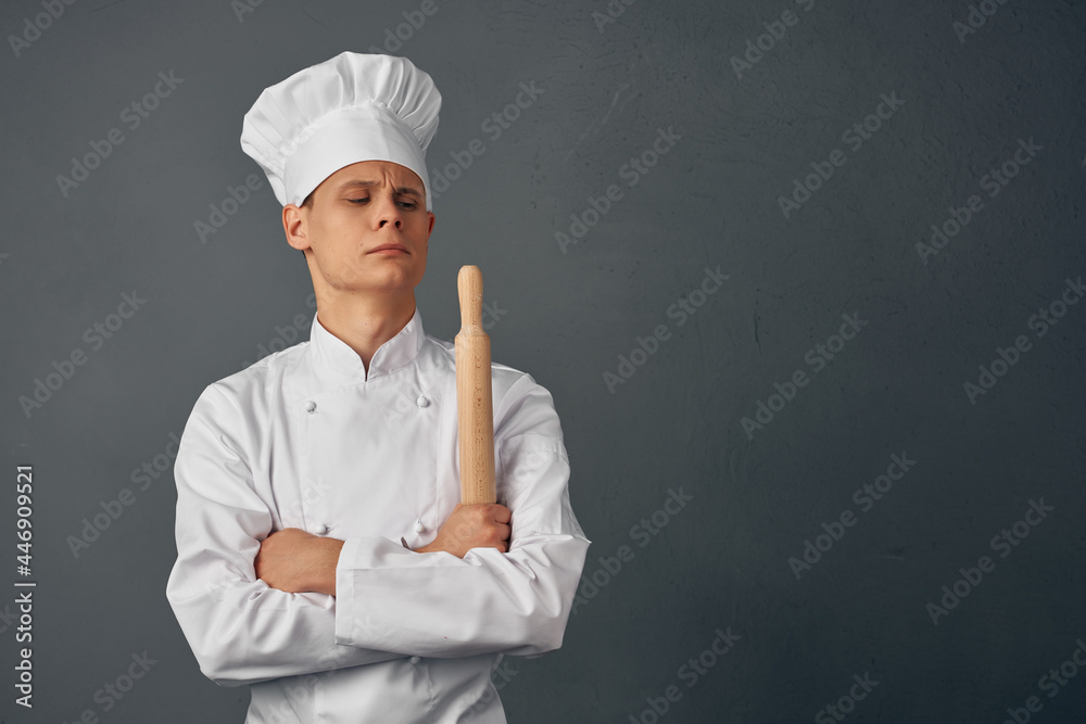 Cheerful chef in uniform kitchen items in the hands of a professional restaurant Cheerful chef in uniform kitchen items in the hands of a professional restaurant