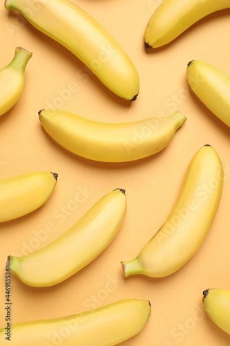 Sweet ripe baby bananas on light orange background, flat lay