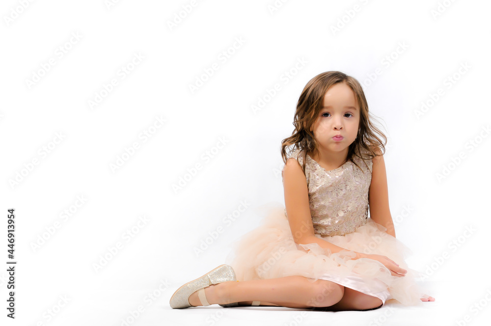 Portrait of happy pretty curly little girl relaxing, sitting and posing over white background Portrait of happy pretty curly little girl relaxing, sitting and posing over white background