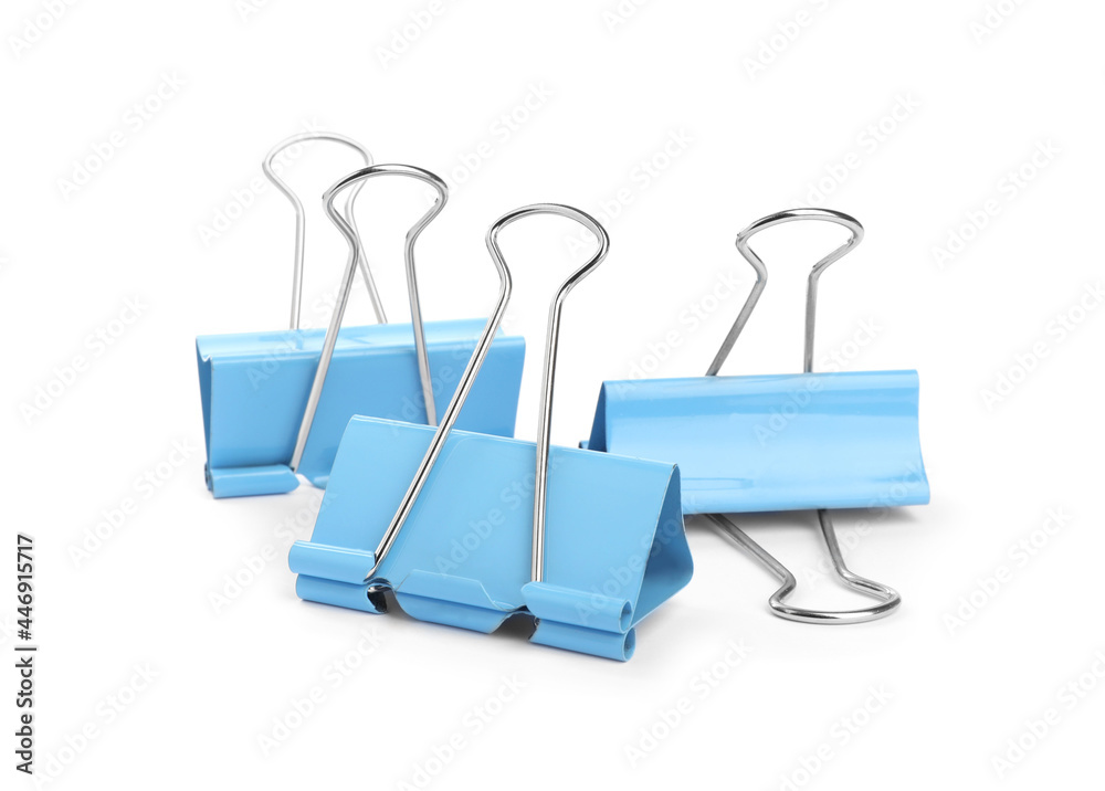 Fototapeta premium Light blue binder clips on white background. Stationery