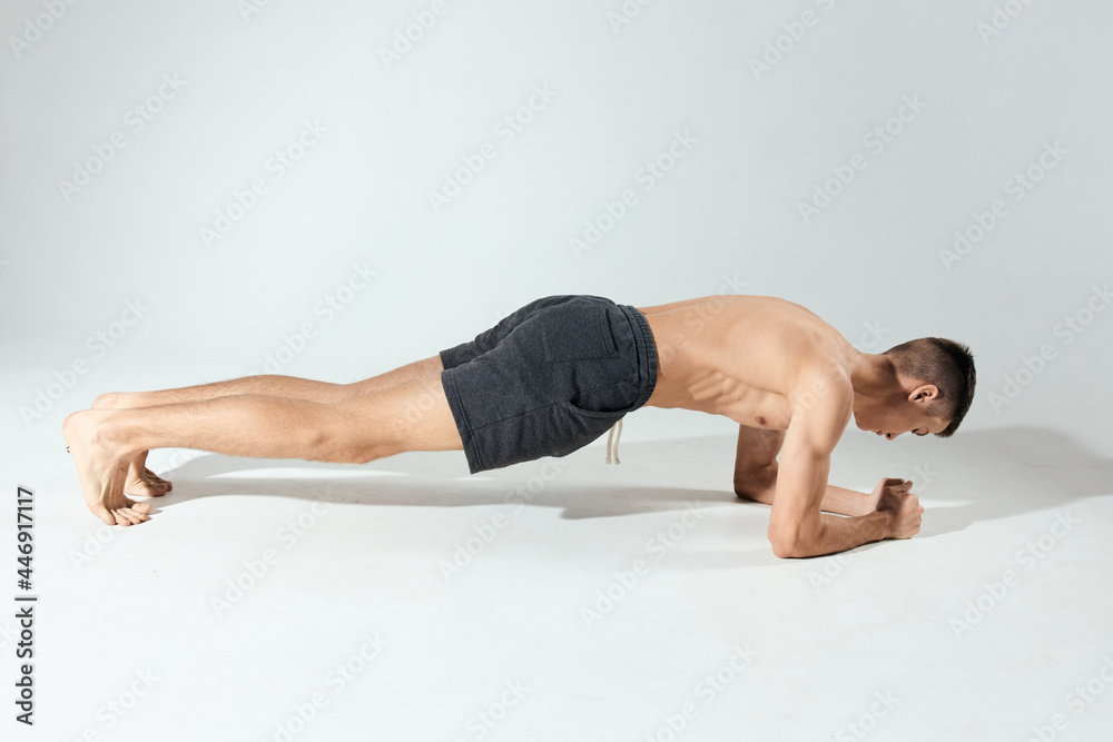 sports guy doing push-ups indoors on elbows in full growth sports guy doing push-ups indoors on elbows in full growth