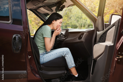 Young woman suffering from nausea in car