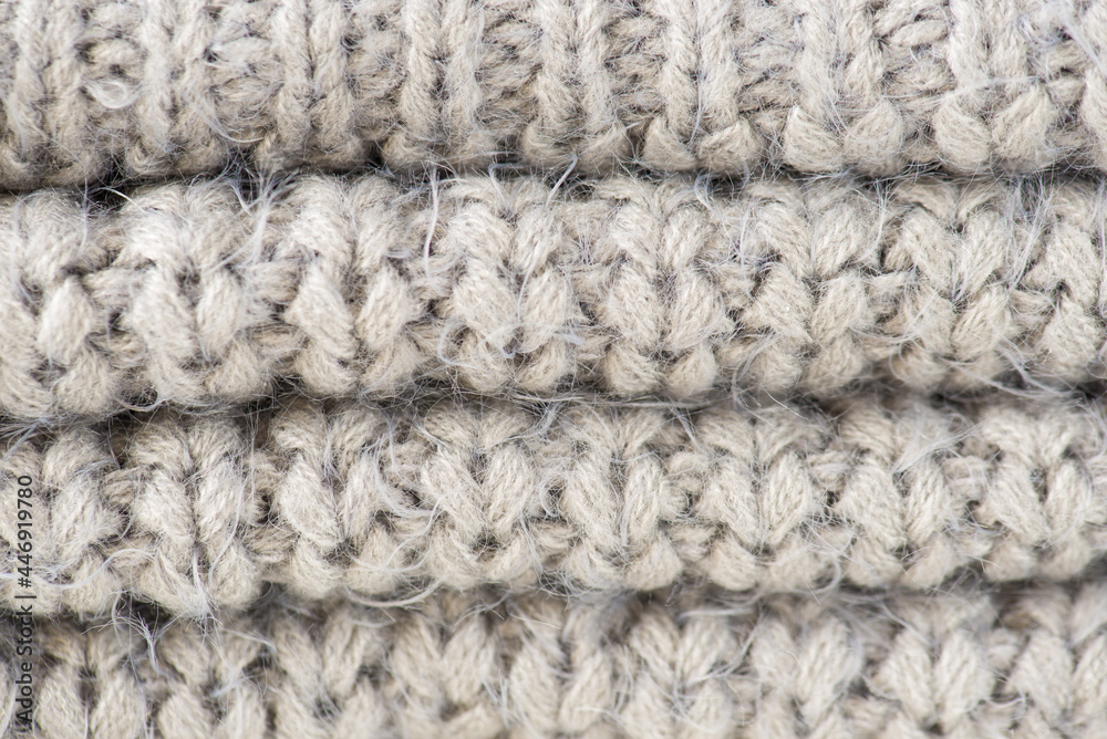 Closeup photo of folded knitted grey fabric texture
