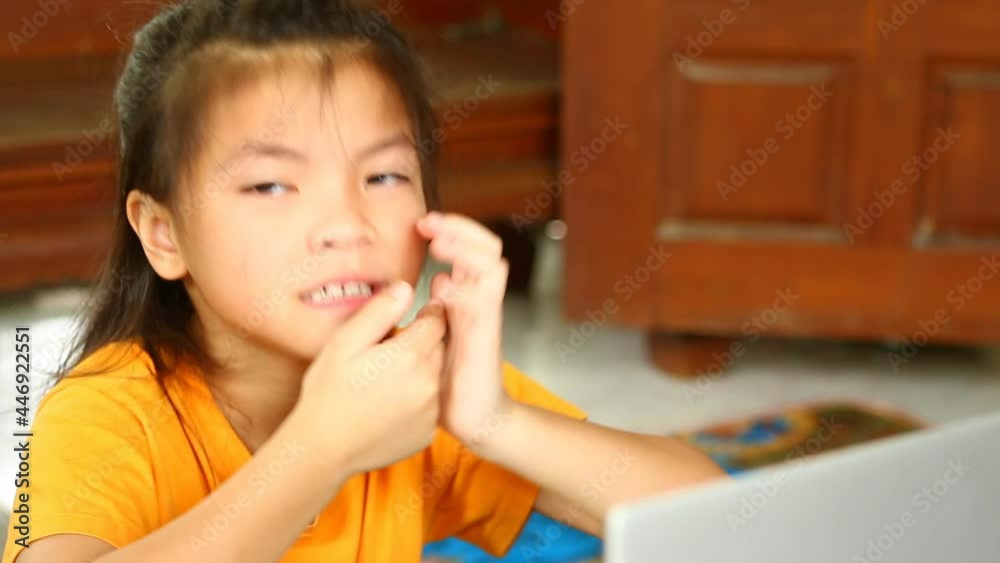 Thai child yawning while learning online by laptop ,indoor Chiangmai Thailand. Thai child yawning while learning online by laptop ,indoor Chiangmai Thailand.
